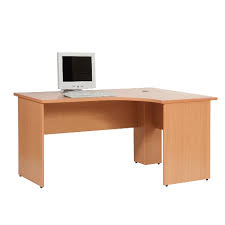 L-shaped office desk with light brown finish and computer setup in a corner workspace